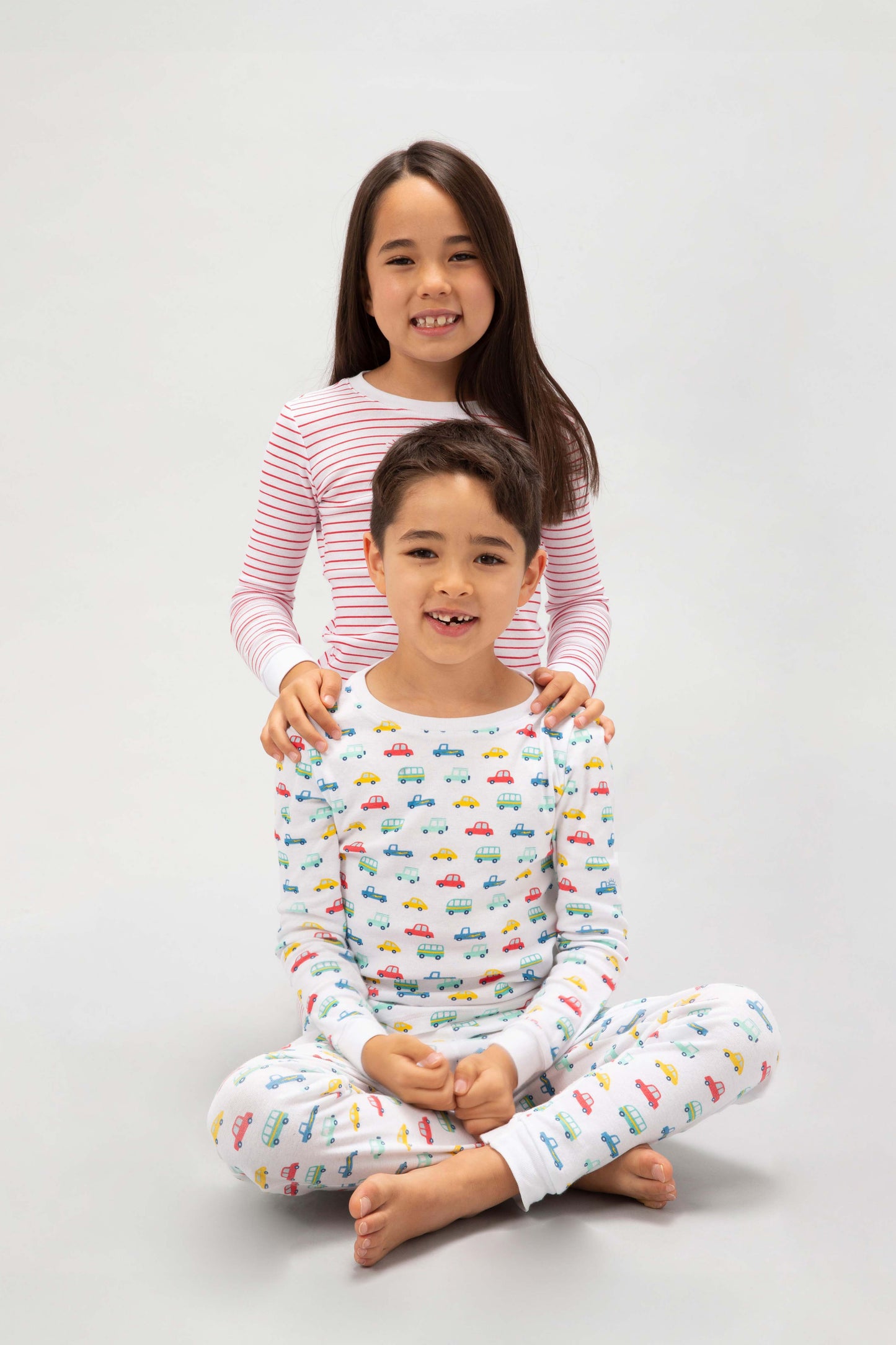 2 models sitting, one in a brightly colorful vehicles print, the other in red stripes prints.
Pajamas are white, lightweight, fabric with vibrant, colorful prints. Pajamas are long-sleeved and made from GOTS certified, 100% organic cotton.
good morning monsters pajamas, loungewear, sleepwear, pajamas, boys, girls, baby, unisex