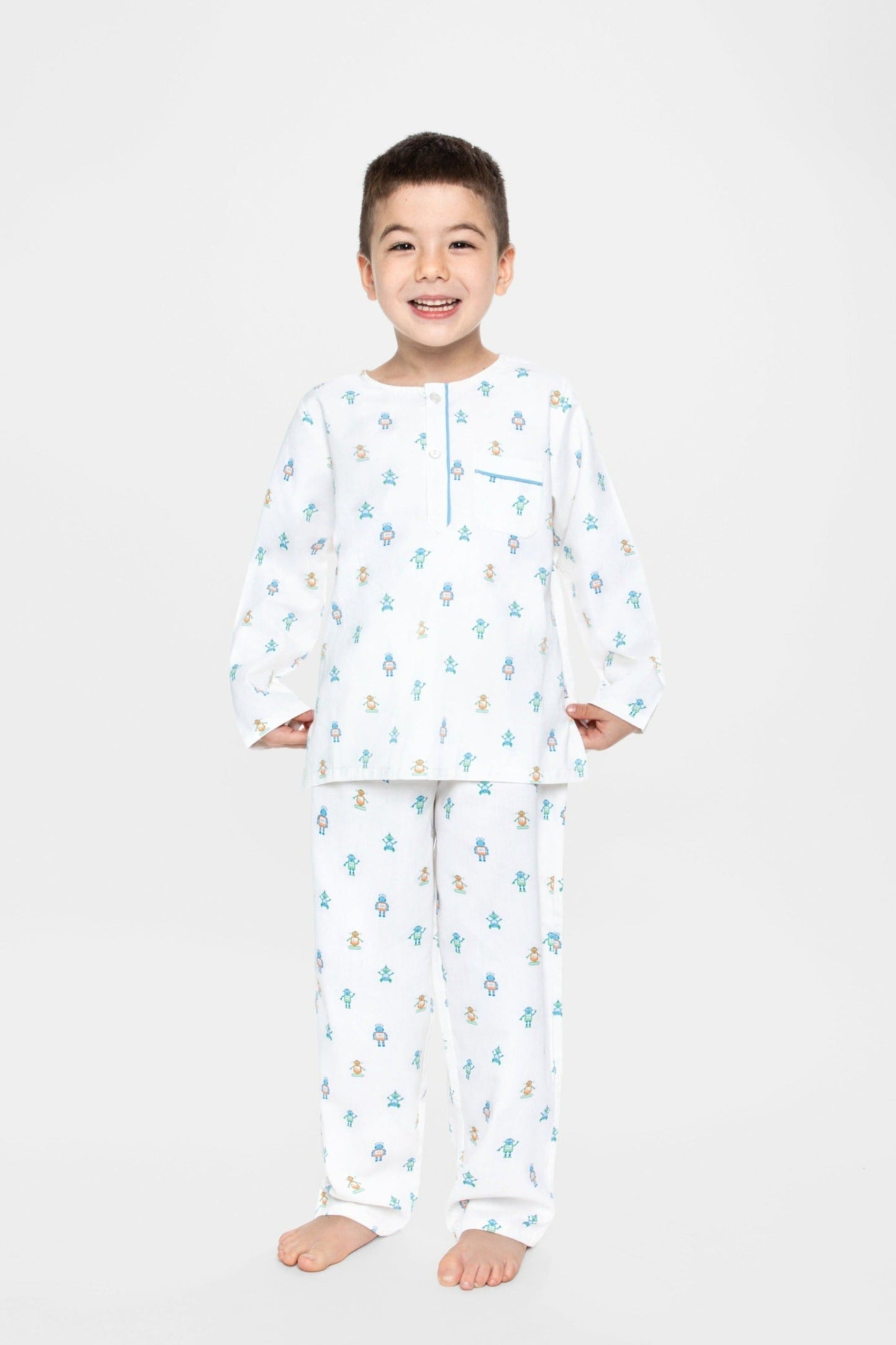 model wearing robots print pajamas (solid white fabric with colorful robots), good morning monsters woven pajamas, loungewear, sleepwear, loose-fitting pajamas, boys, girls, baby, unisex