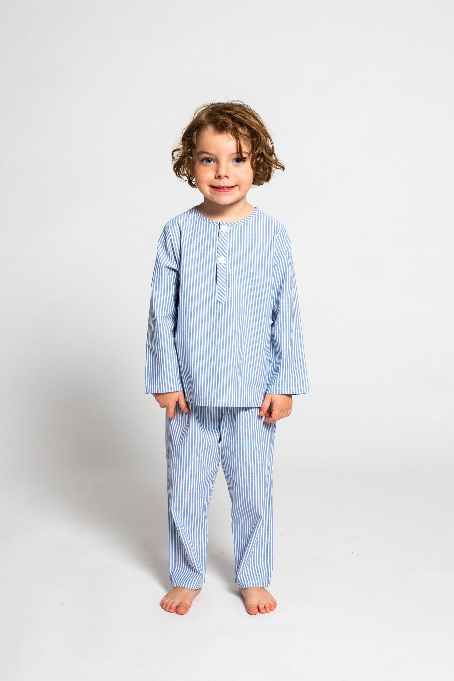 model wearing blue and white pinstripe pajamas, good morning monsters woven pajamas, loungewear, sleepwear, loose-fitting pajamas, boys, girls, baby, unisex