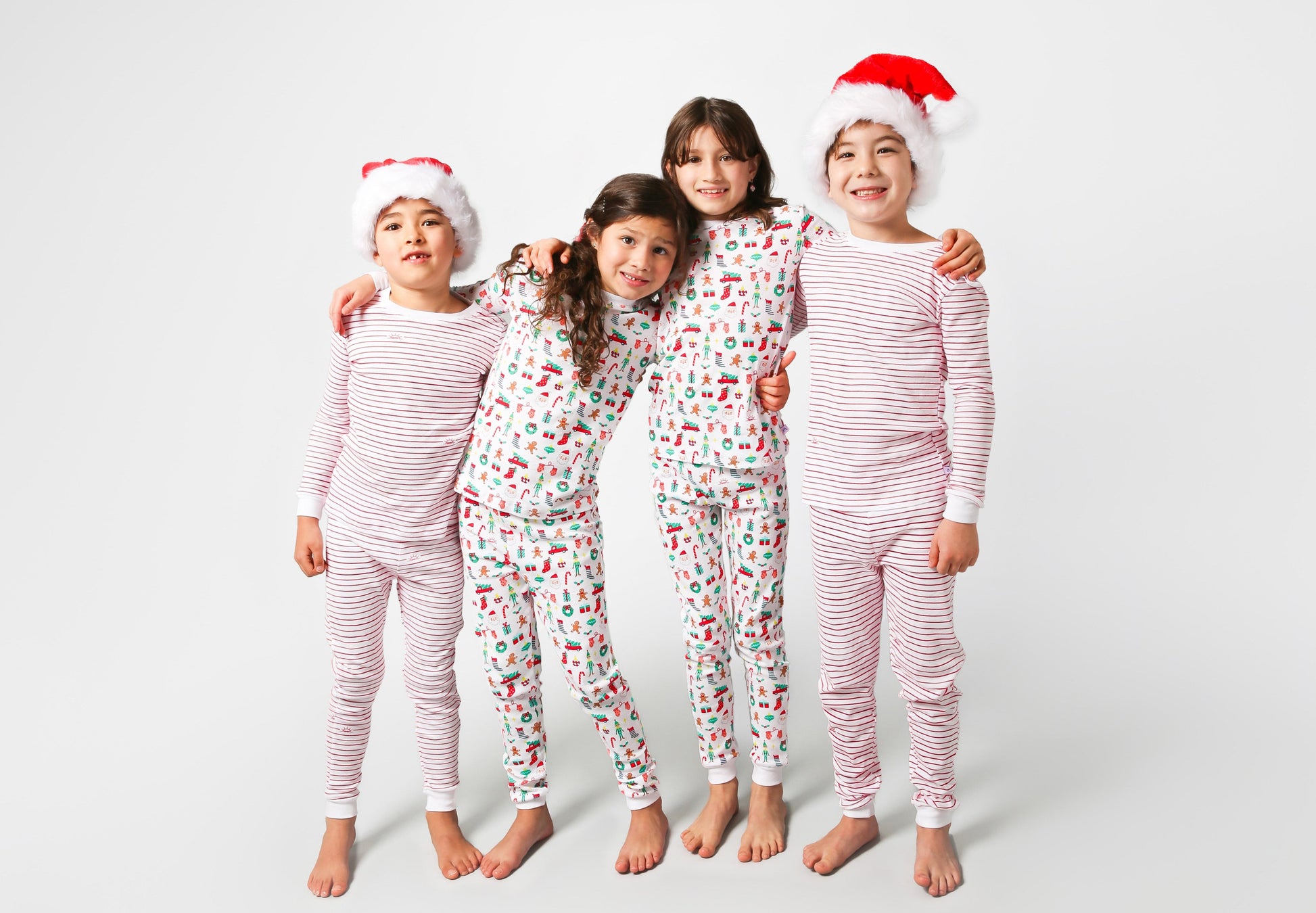 4 models posing, 2 with Santa hats
2 models wearing Christmas, festive, Santa, Elves, Classic Christmas, Holiday, Ornaments, Stockings, Gingerbread, Red Trucks pajama set / 2 models wearing hand drawn red stripes pajama set  
Pajamas are white, lightweight fabric with a vibrant Christmas print.   Pajamas are long-sleeved and made from GOTS certified, 100% organic cotton.
good morning monsters pajamas, loungewear, sleepwear, pajamas, boys, girls, baby, unisex