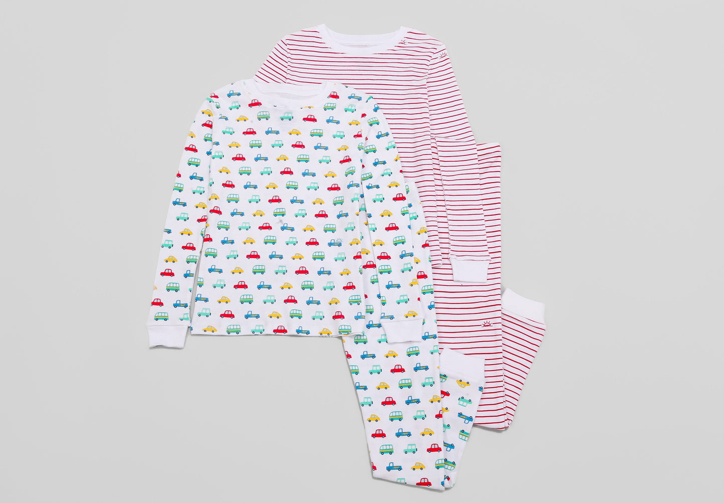 View of 2 PJ Sets side by side (Vehicles & Red Stripes) - Tops & Bottoms. Pajamas are white fabric with vibrant vehicles or bright red stripes, along with our fun GMM logo.  Pajamas are long-sleeved and made from 100% GOTS certified organic cotton.
good morning monsters pajamas, loungewear, sleepwear, pajamas, boys, girls, baby, unisex