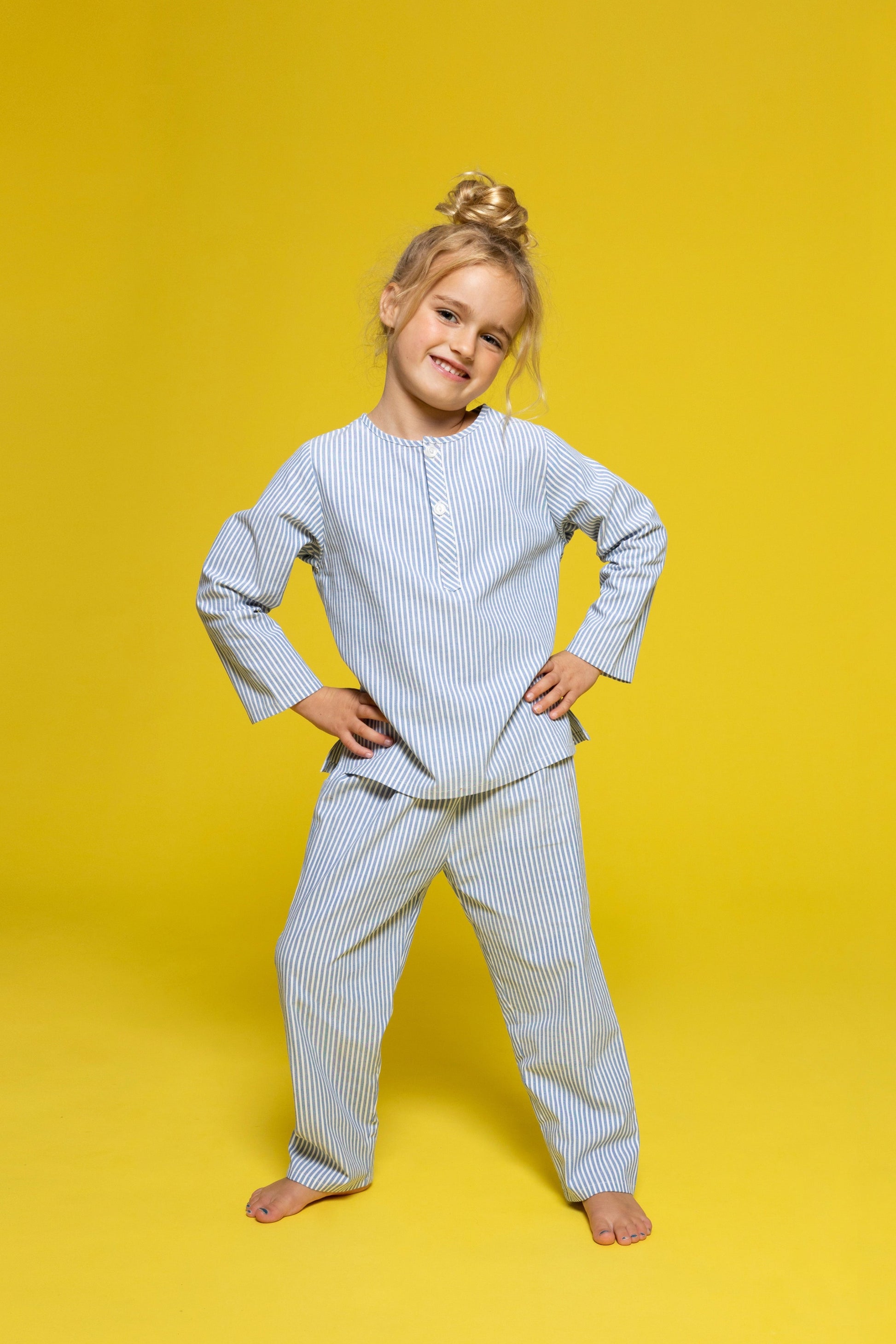 model wearing blue and white pinstripe pajamas, good morning monsters woven pajamas, loungewear, sleepwear, loose-fitting pajamas, boys, girls, baby, unisex