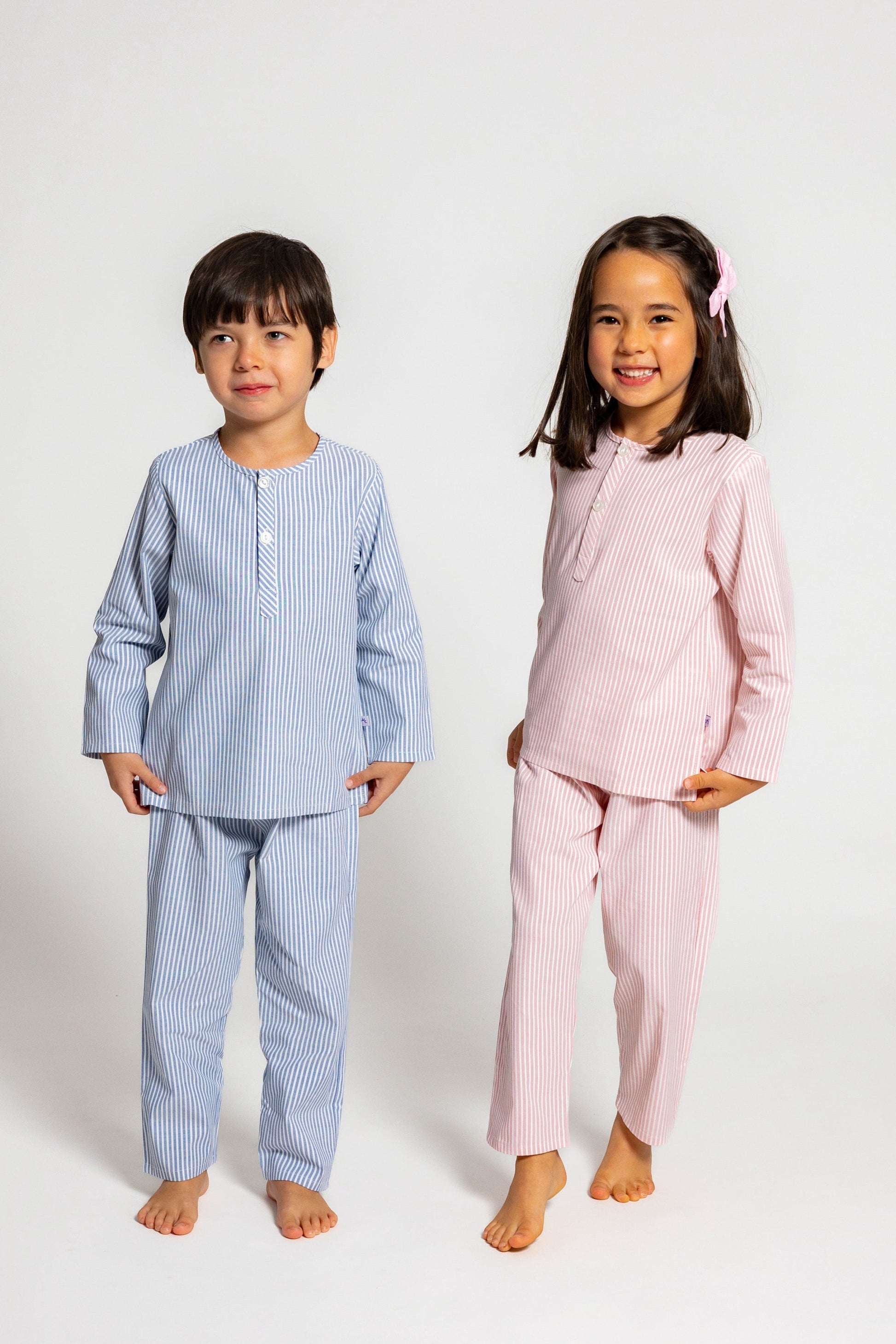 one model wearing blue and white pinstripe pajamas and the other model wearing pink and white pinstripe pajamas, good morning monsters woven pajamas, loungewear, sleepwear, loose-fitting pajamas, boys, girls, baby, unisex