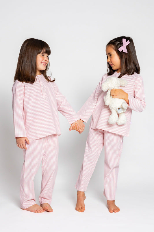 two models wearing pink and white pinstripe pajamas (one model is holding jellycat doll), good morning monsters woven pajamas, loungewear, sleepwear, loose-fitting pajamas, boys, girls, baby, unisex