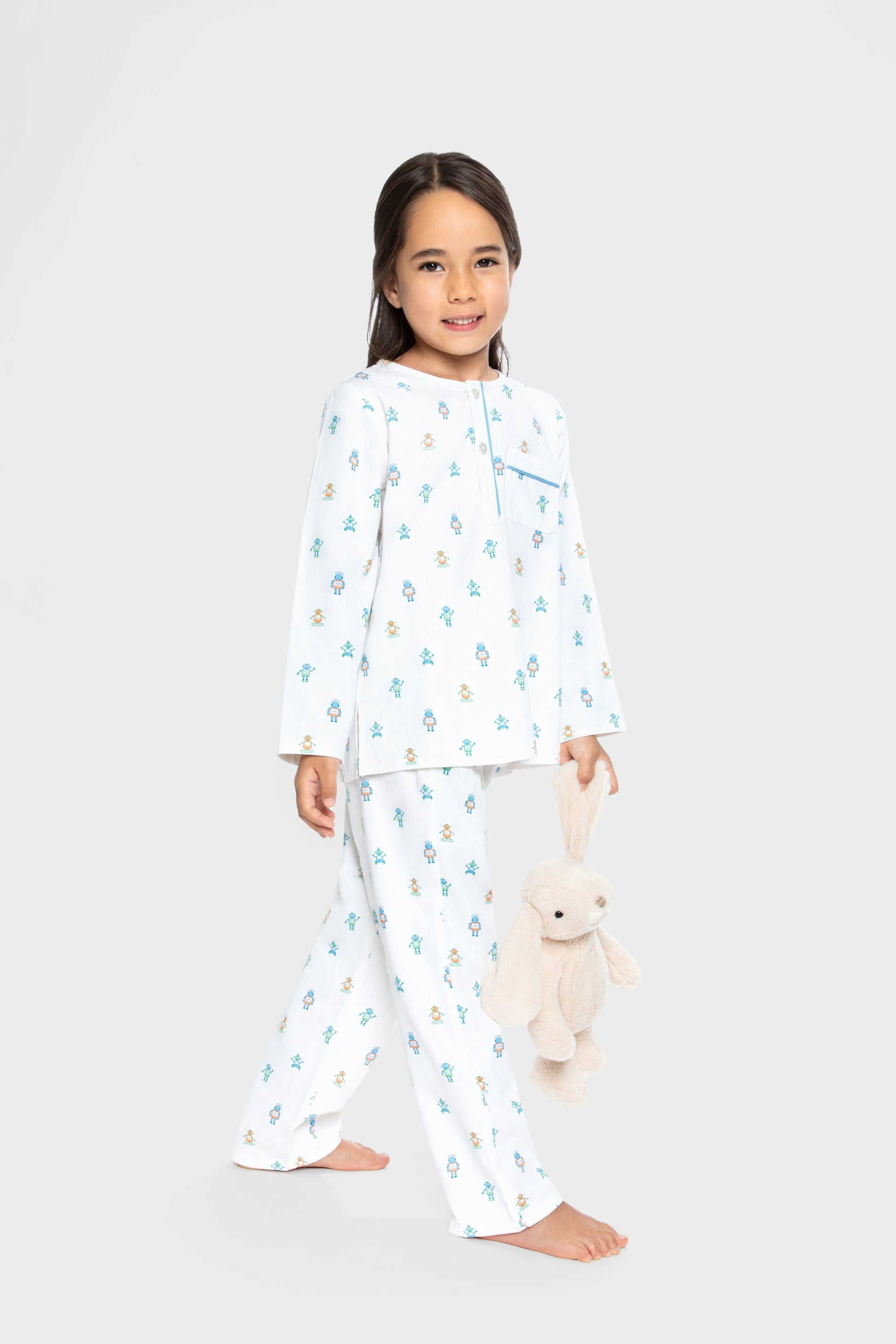 model wearing robots print pajamas (solid white background with colorful robots), good morning monsters woven pajamas, loungewear, sleepwear, loose-fitting pajamas, boys, girls, baby, unisex