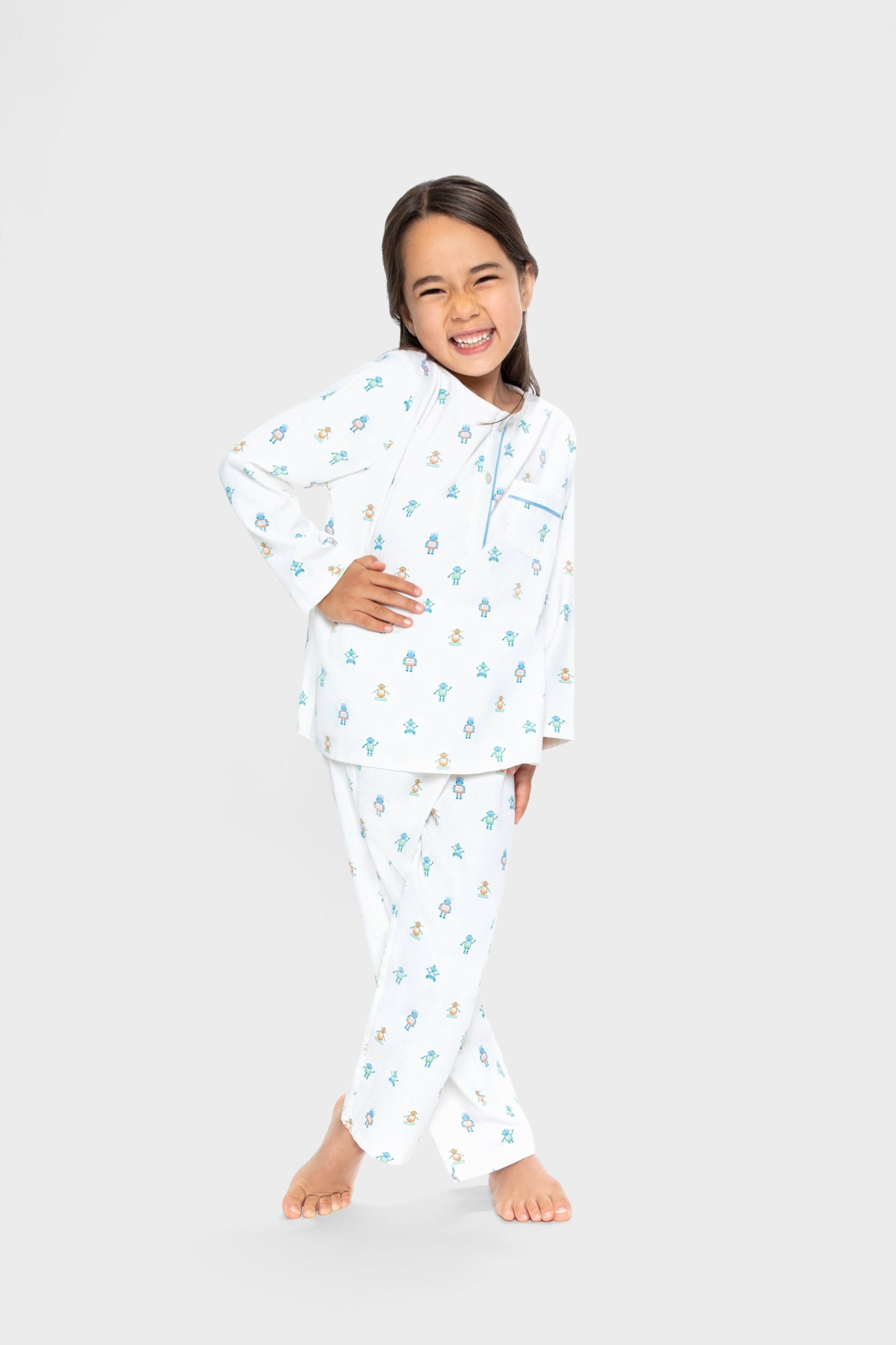 model wearing robots print pajamas (solid white background with colorful robots), good morning monsters woven pajamas, loungewear, sleepwear, loose-fitting pajamas, boys, girls, baby, unisex