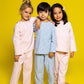 three models wearing good morning monsters pinstripe pajamas (two models are wearing pink pinstripes, the center model is wearing blue pinstripes), good morning monsters woven pajamas, loungewear, sleepwear, loose-fitting pajamas, boys, girls, baby, unisex