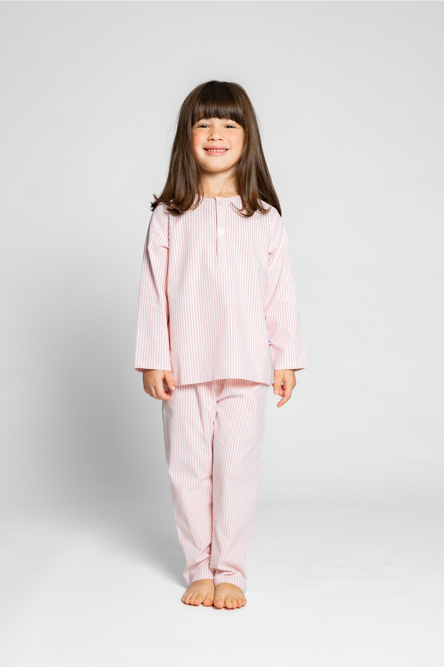 model wearing pink and white pinstripe pajamas, good morning monsters woven pajamas, loungewear, sleepwear, loose-fitting pajamas, boys, girls, baby, unisex