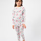 Front view of model wearing Christmas, festive, Santa, Elves, Classic Christmas, Holiday Ornaments, Stockings, Gingerbread, Red Trucks pajama set.  
Pajamas are white, lightweight fabric with a vibrant Christmas print.  Pajamas are long-sleeved and made from GOTS certified, 100% organic cotton.
good morning monsters pajamas, loungewear, sleepwear, pajamas, boys, girls, baby, unisex