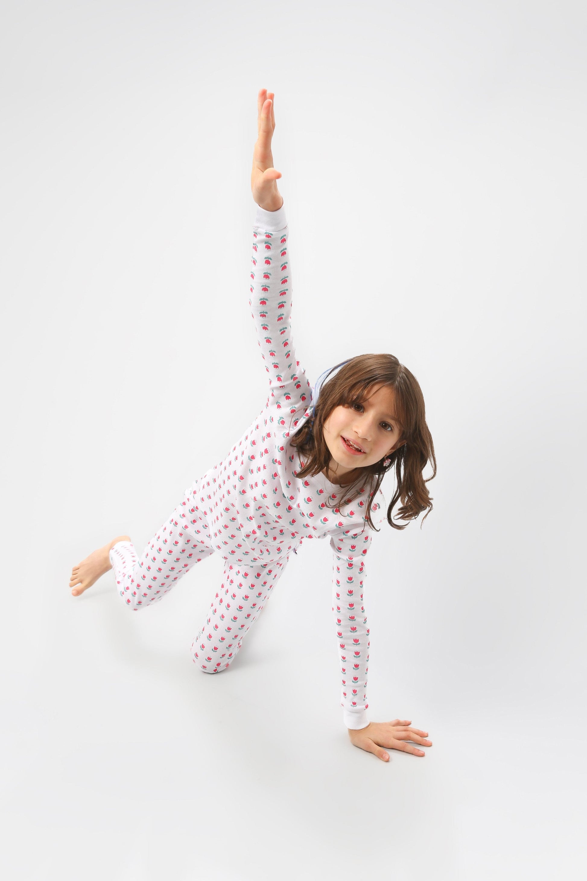 Model posing wearing the tulips pajama set.  Pajamas are white fabric with vibrant, bright pink tulips with turquoise leaves.  Pajamas are long-sleeved and made from GOTS certified, 100% organic cotton.
good morning monsters pajamas, loungewear, sleepwear, pajamas, boys, girls, baby, unisex