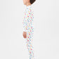 Side view of model wearing vehicles pajama set.  
Pajamas are white, lightweight fabric with a vibrant, colorful vehicles print with cars, jeeps, trucks, and buses.  Pajamas are long-sleeved and made from 100% GOTS certified organic cotton.
good morning monsters pajamas, loungewear, sleepwear, pajamas, boys, girls, baby, unisex