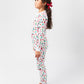 Side view of model wearing Christmas, festive, Santa, Elves, Classic Christmas, Holiday Ornaments, Stockings, Gingerbread, Red Trucks pajama set.  
Pajamas are white, lightweight fabric with a vibrant Christmas print.  Pajamas are long-sleeved and made from GOTS certified, 100% organic cotton.
good morning monsters pajamas, loungewear, sleepwear, pajamas, boys, girls, baby, unisex