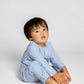 model wearing blue and white pinstripe pajamas, good morning monsters woven pajamas, loungewear, sleepwear, loose-fitting pajamas, boys, girls, baby, unisex